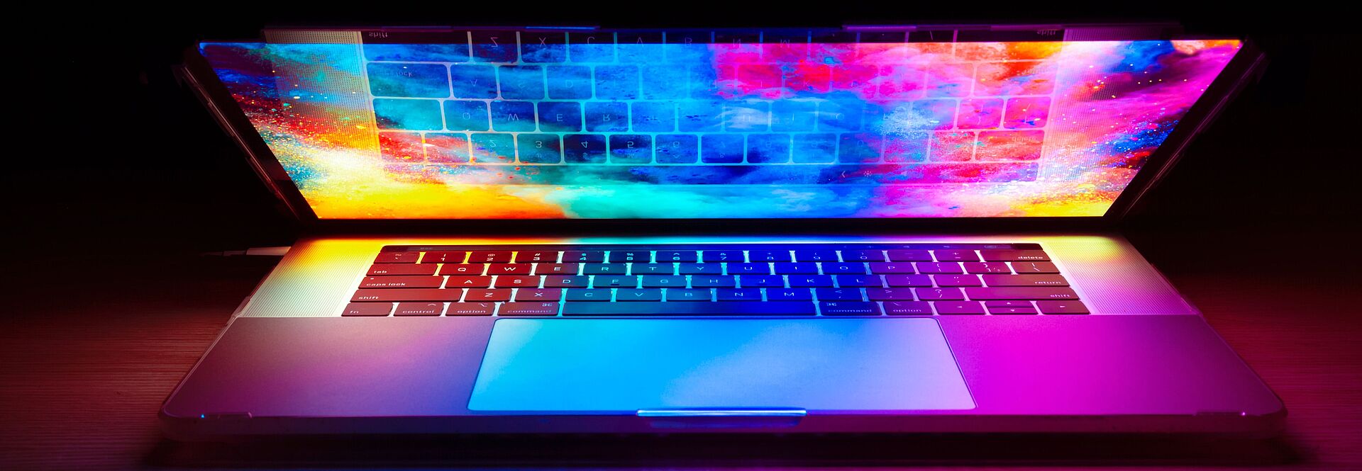 Halb geöffneter Laptop mit bunten Farben am Display