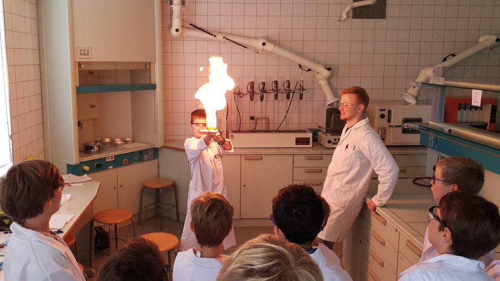 Kinder im Labor die ein Experiment mit Feuer ausführen