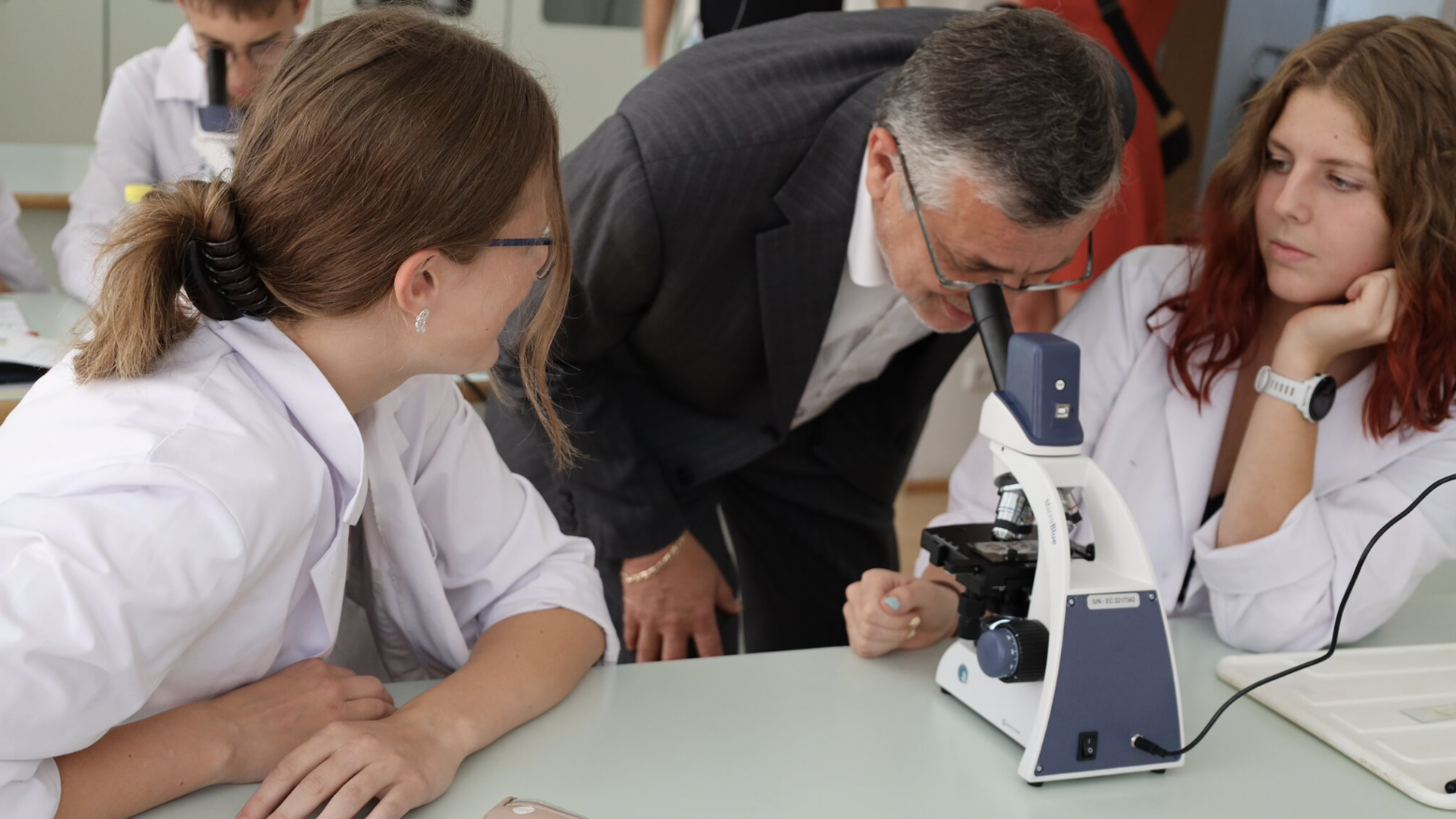 Bildungsdirektor Alfred Klampfer versucht Zwiebelzellen unter dem Mikroskop zu erkennen. 